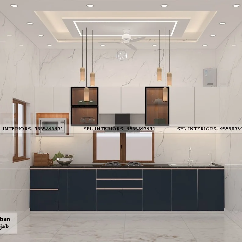 Straight kitchen layout with white overhead cabinets, glass display units, hanging pendant lights, a window above the cooktop, and navy blue base cabinets.