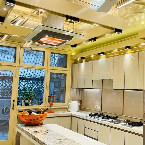 Modular kitchen with cream glossy cabinets, gas stove and large window