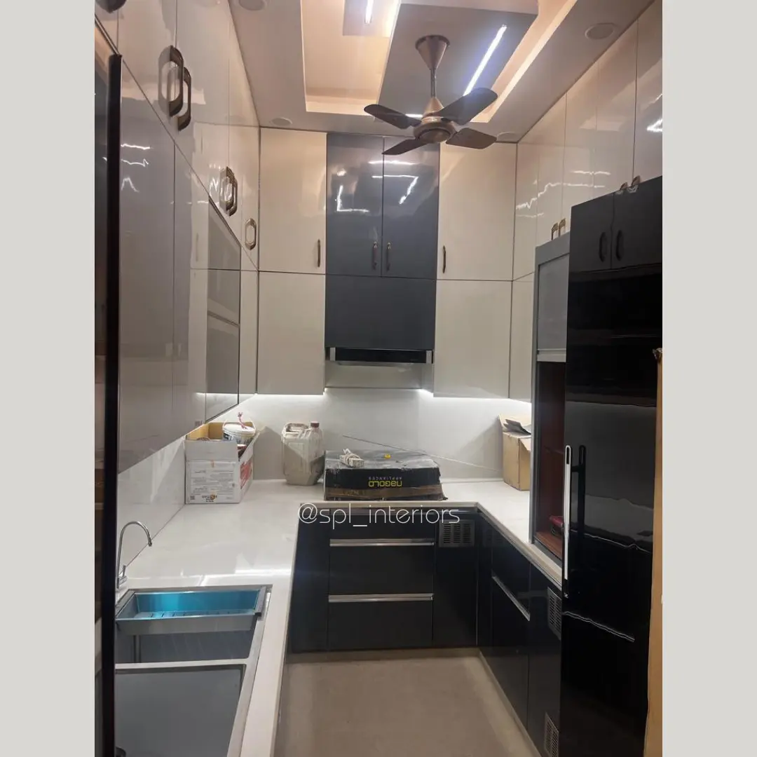 U-shaped modular kitchen with glossy black base cabinets and white overhead units
